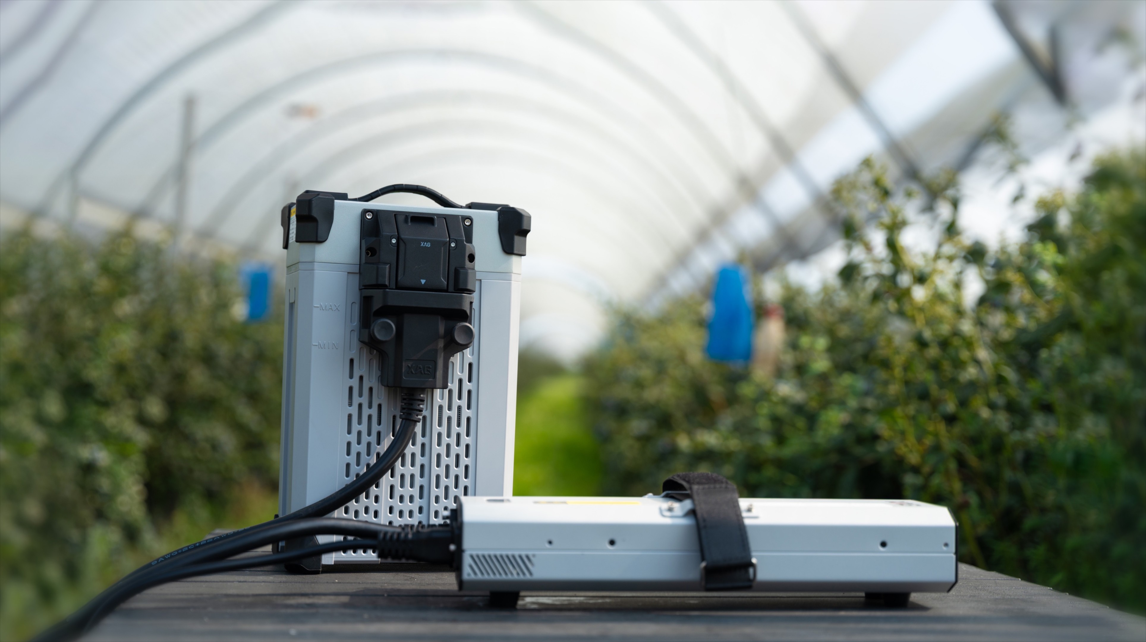 XAG Smart SuperCharge battery beside the R100 rover