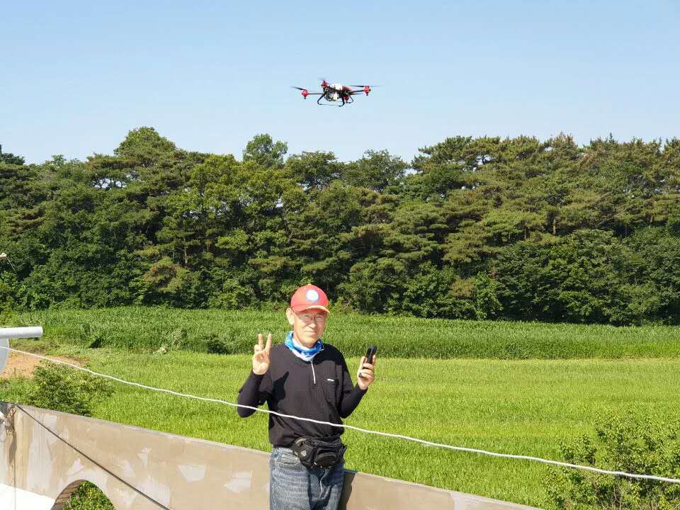 Jun Bon Soo operating XAG’s plant protection drone with a pilot phone