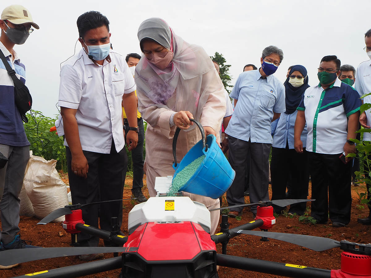 Plantation Industries and Commodities Minister Zuraida was adding fertilizers into the container of XAG Agricultural Drone.