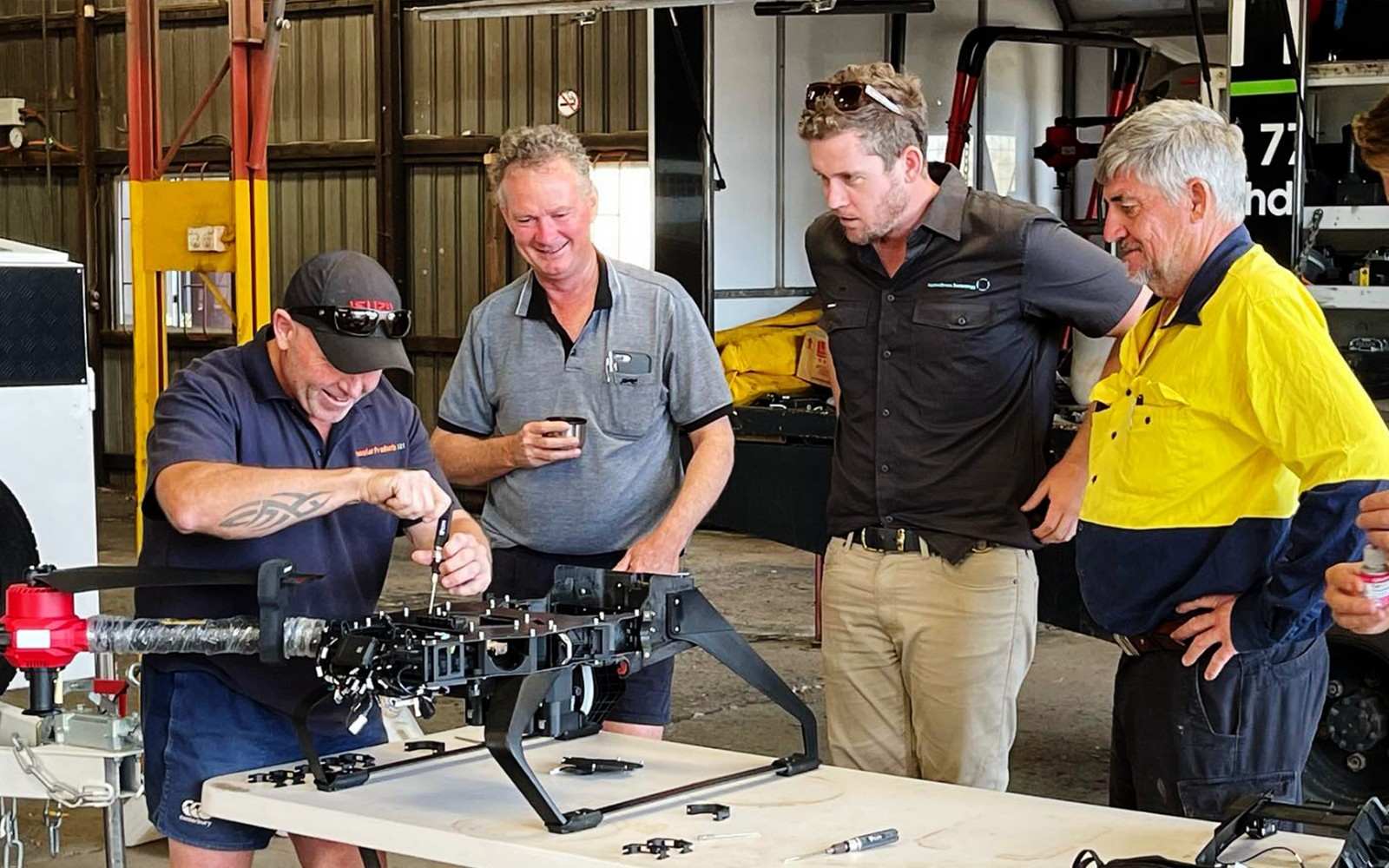 Being watched by colleagues might be a bit nervous, but attention is needed while tightening the screws on drone. (Australia, source: Oztech Drones)