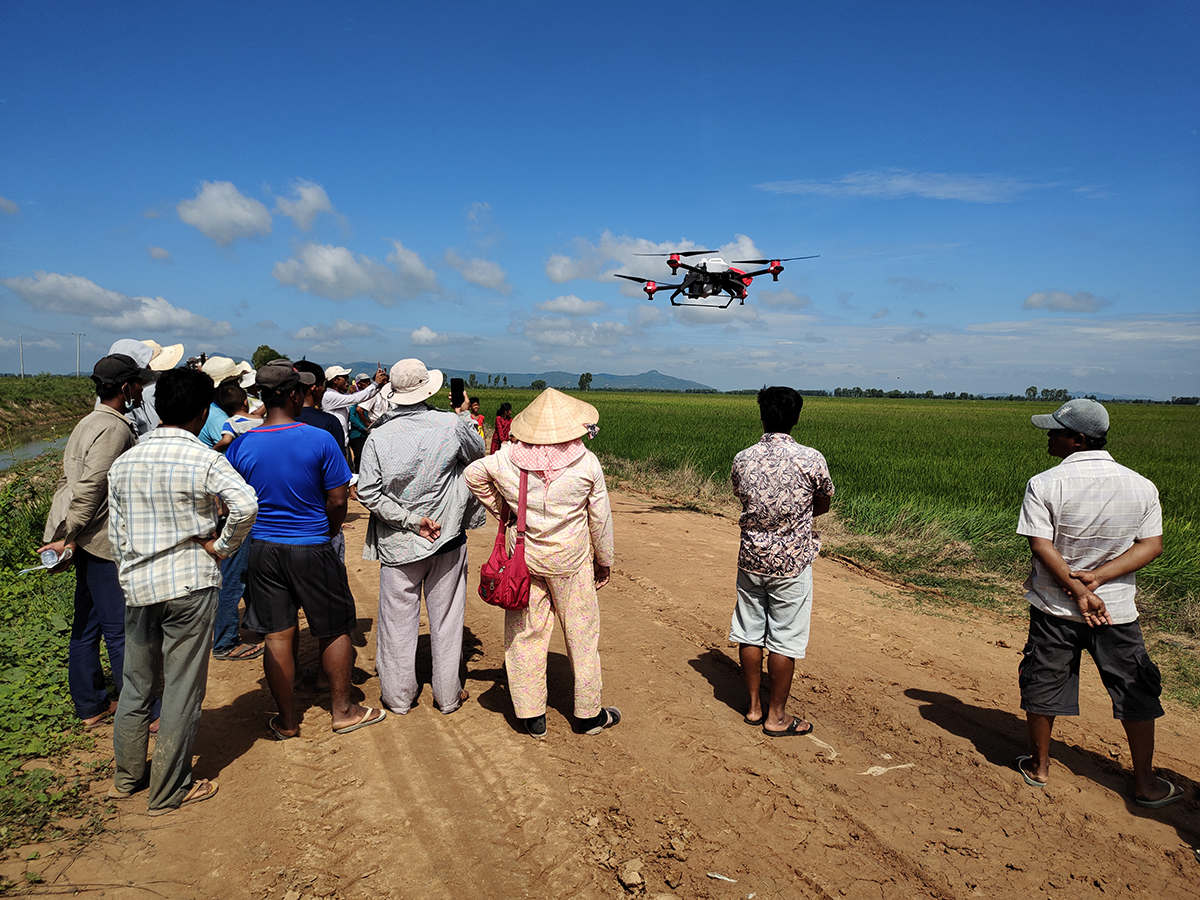 Local farmers watched the demonstration of XAG agricultural drone spraying crops